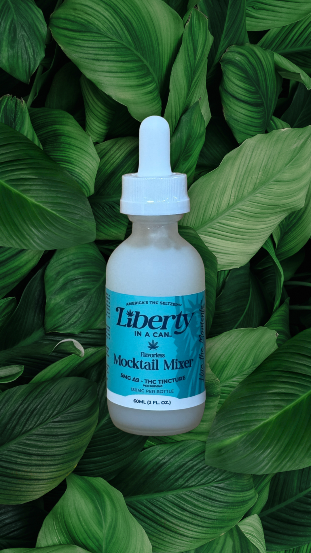 Bottle of Liberty Mocktail Mixer on a green leafy background